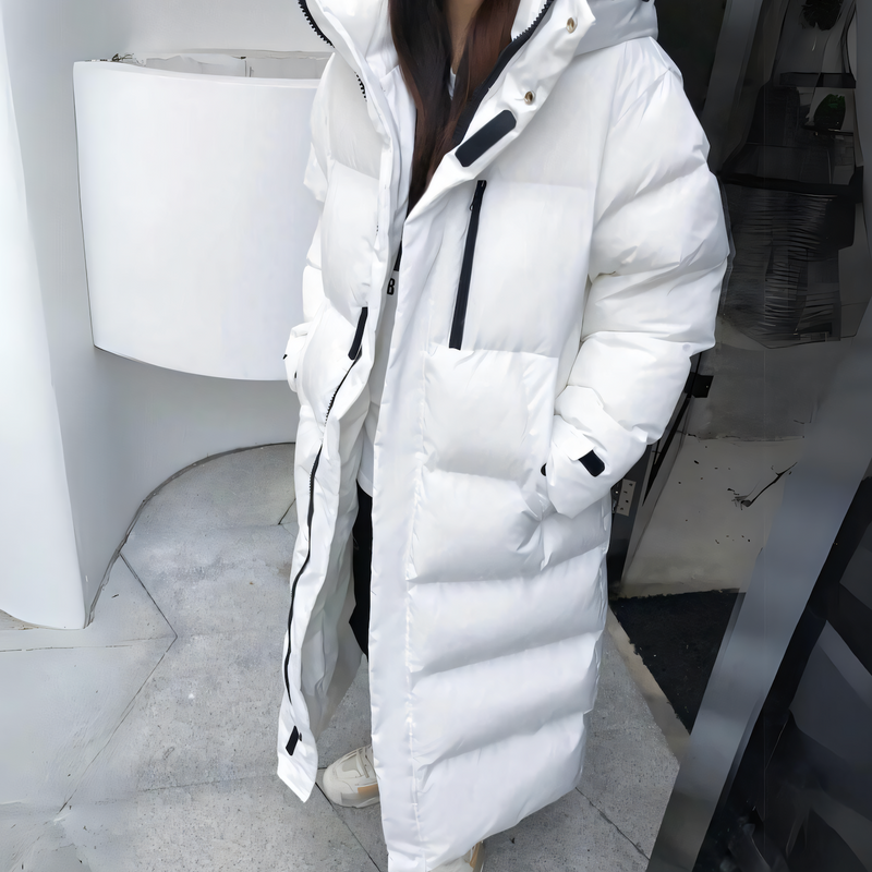Women's puffer jacket with slanted pockets, zipper, hood, and long fit with thick pockets
